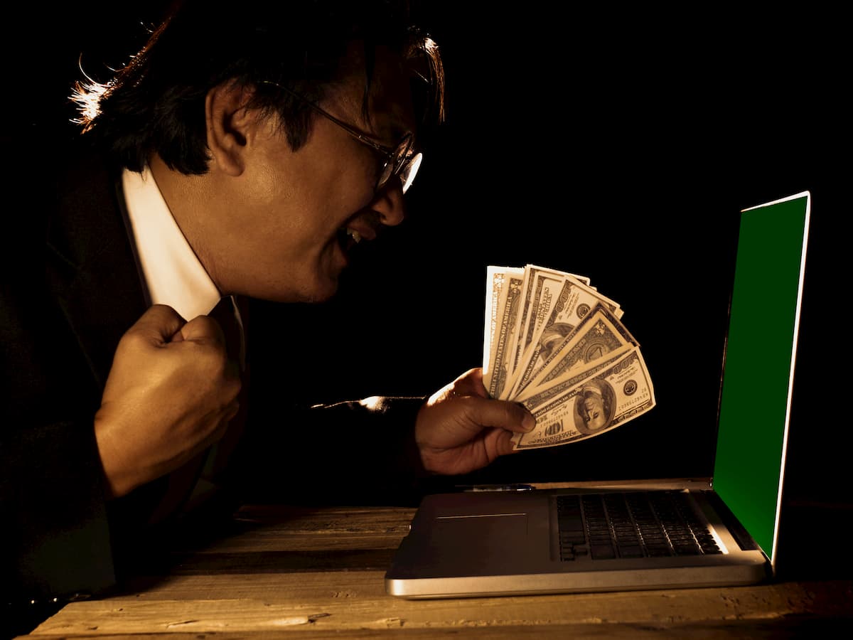 gambler in front of his laptop with money to gamble