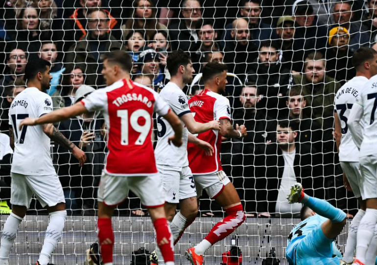 Arsenal survive Spurs fightback to boost title charge